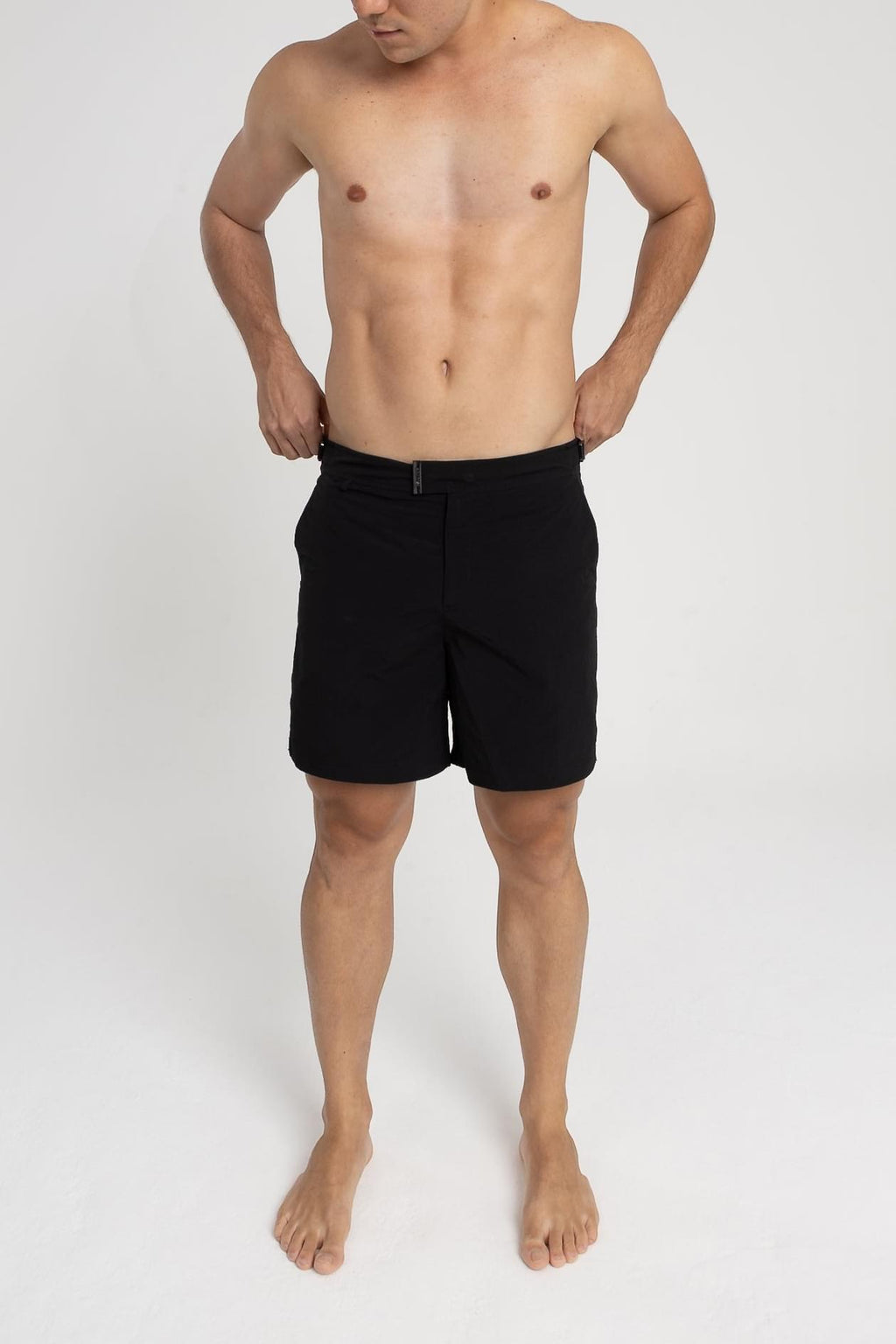 Homem usando short de praia RAUTER PRETO MÉDIO, com tecido de secagem rápida e estilo sofisticado.