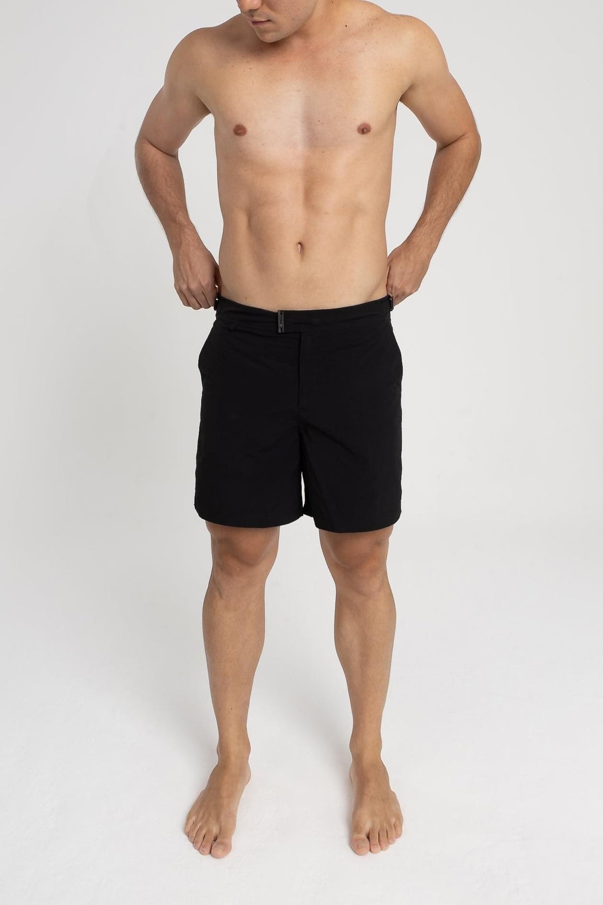 Homem usando short de praia RAUTER PRETO MÉDIO, com tecido de secagem rápida e estilo sofisticado.