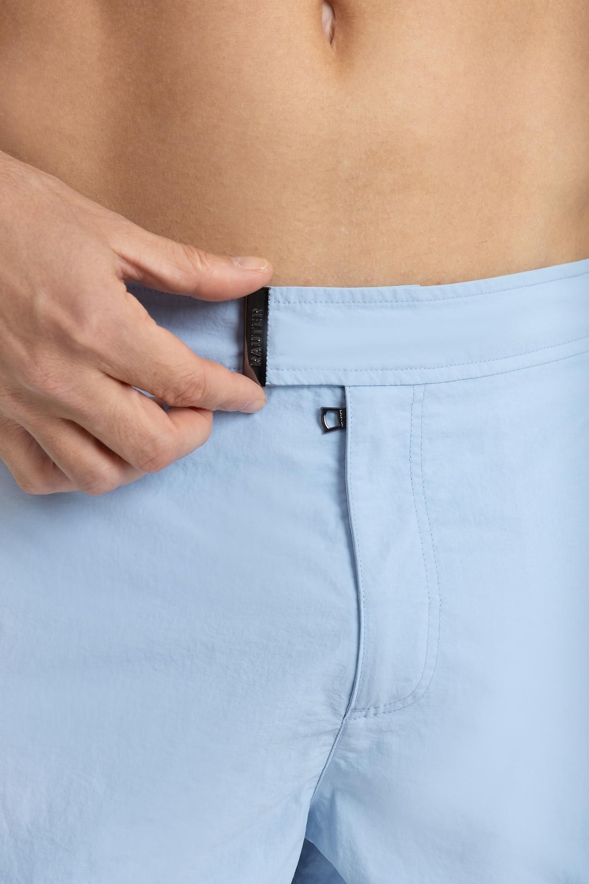 Detalhe da cintura do short RAUTER AZUL BEBÊ MÉDIO com fivela ajustável em nylon reciclado.