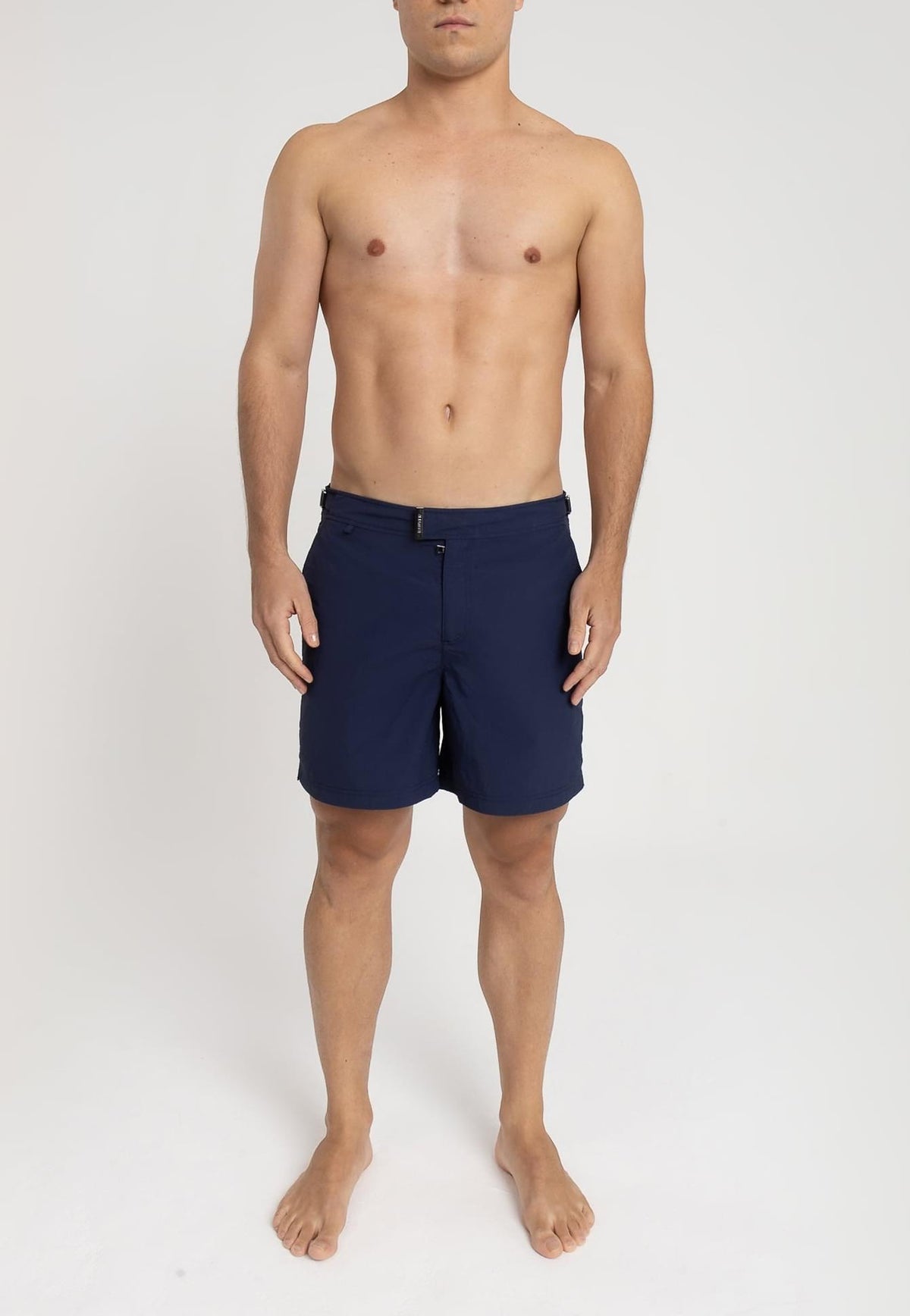Modelo usando o short de praia RAUTER AZUL MARINHO MÉDIO, nylon reciclado, corte médio.