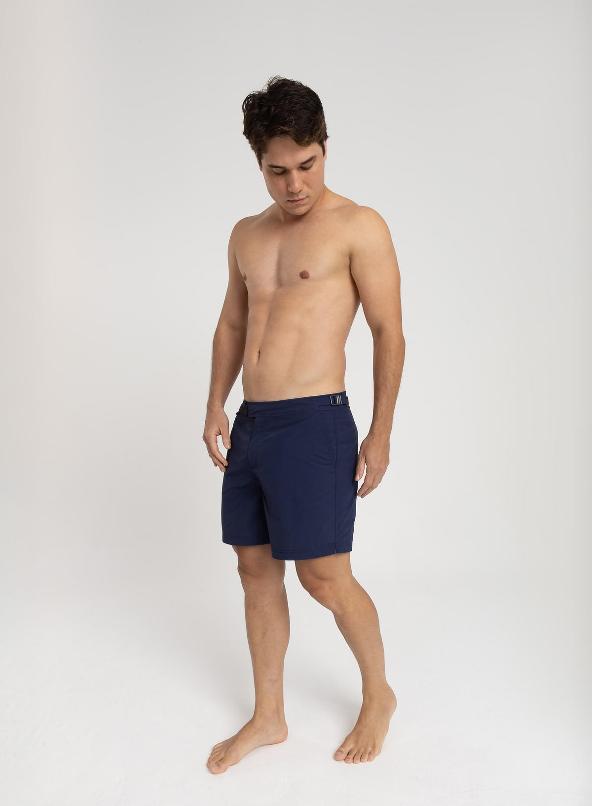 Homem usando short de praia RAUTER AZUL MARINHO MÉDIO, com nylon reciclado e estilo sofisticado.