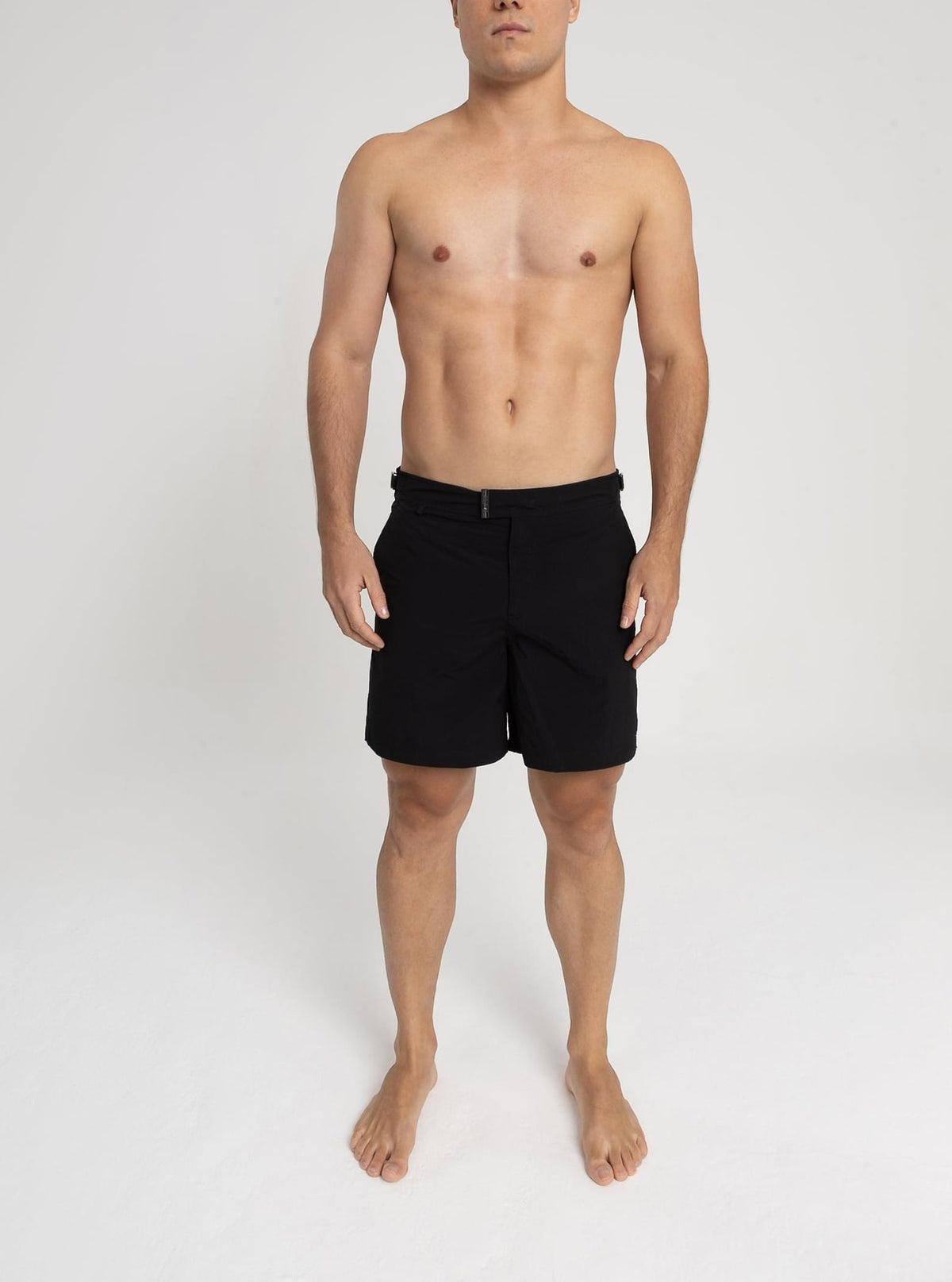 Modelo usando o short de praia RAUTER PRETO MÉDIO, tecido de secagem rápida e corte médio.