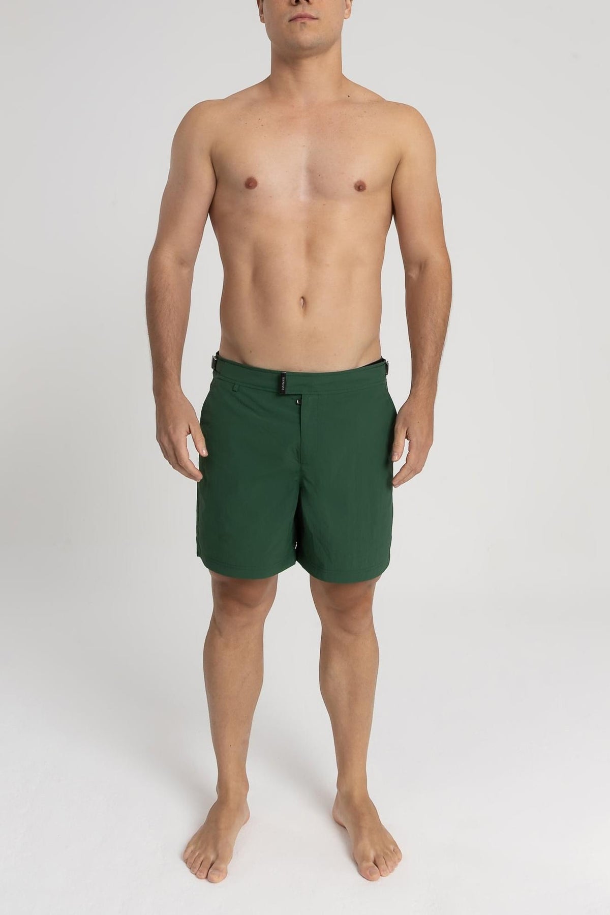 Modelo usando o short de praia RAUTER VERDE MÉDIO, nylon reciclado, corte médio.