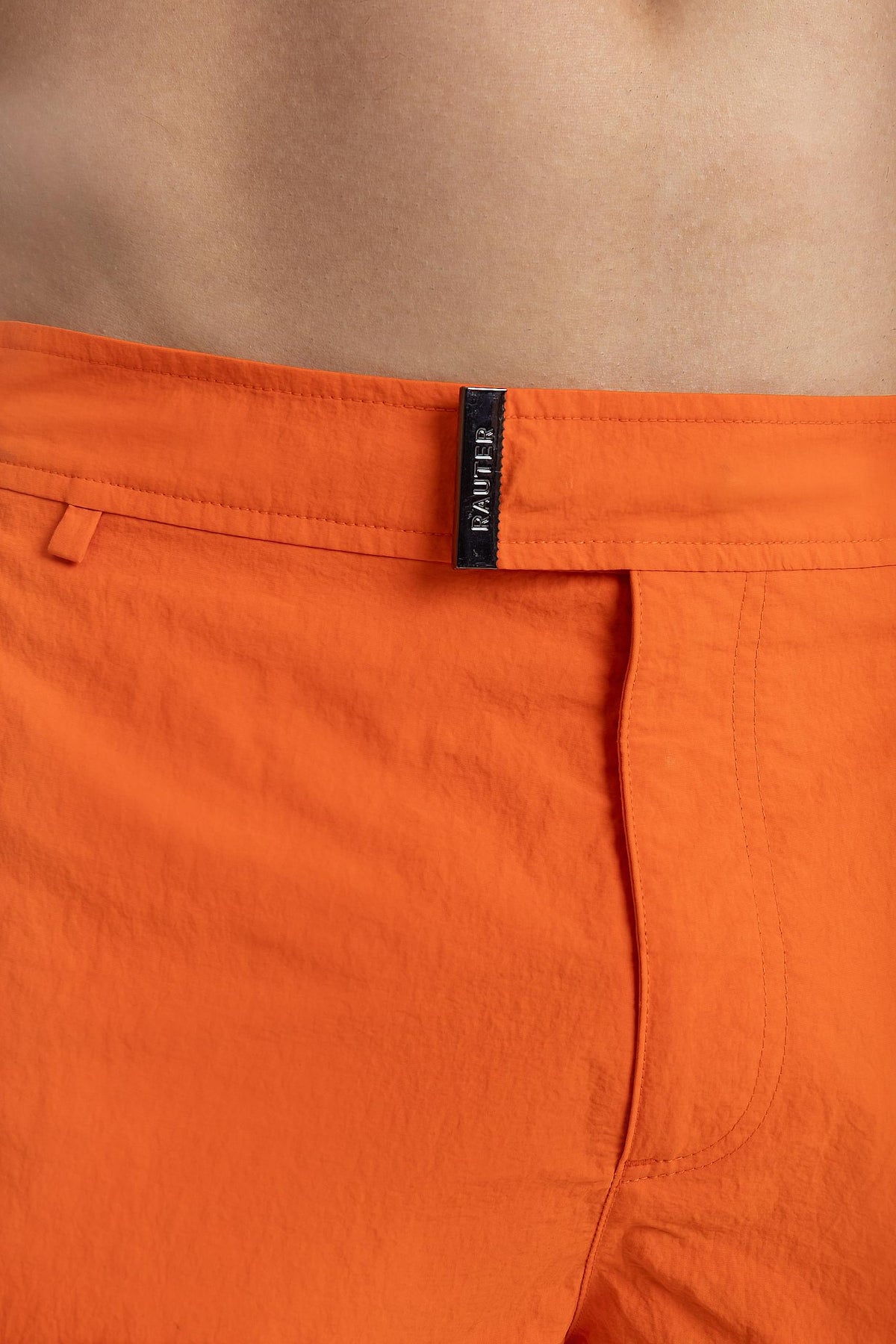 Detalhe da cintura do short RAUTER LARANJA MÉDIO com fivela ajustável em nylon reciclado.
