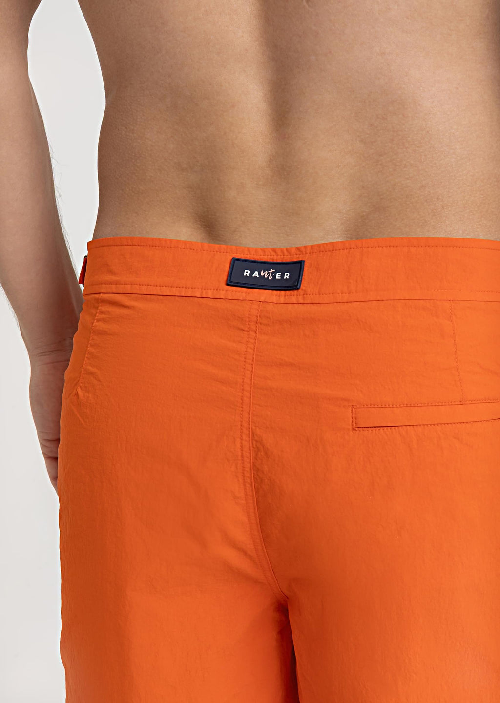RAUTER LARANJA MÉDIO - Detalhe do bolso traseiro em short de praia masculino, acabamento em tecido leve e toque premium.